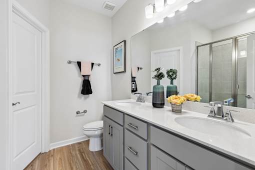 A bathroom with a white toilet, a sink, and a mirror.