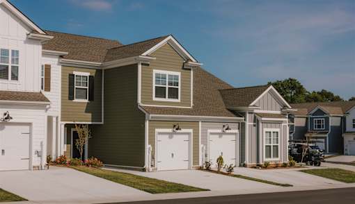 A row of houses with garages on the side.