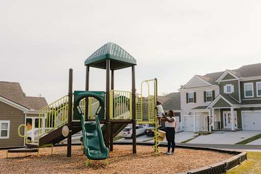 A woman is standing in front of a playground.