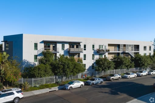 a white and blue building with cars parked in front of it