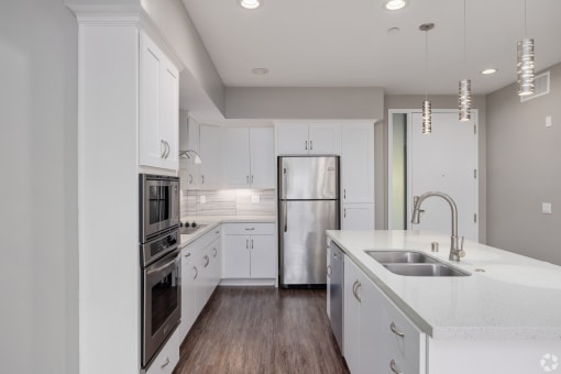 a kitchen with white cabinets and stainless steel appliances