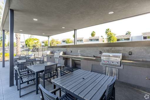 A patio with a grill and seating area.