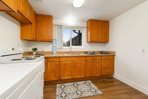 A kitchen with wooden cabinets and a white stove.