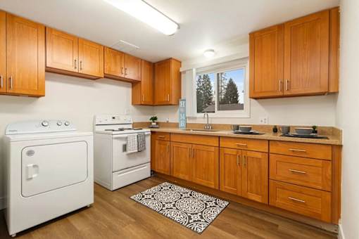 A kitchen with wooden cabinets and a white oven.