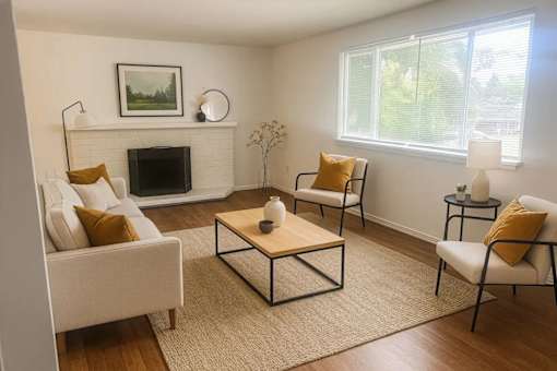 A living room with a fireplace, two chairs, and a coffee table.