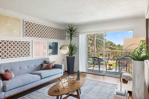 Living room with balcony and modern decor at Skyline at Barton Creek Apartments, Texas, 78758