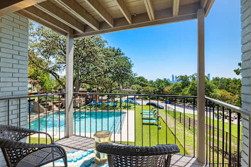 Private balcony overlooking pool and playground at Skyline at Barton Creek Apartments, Texas