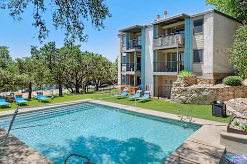 Swimming pool with lounge chairs and building views at Skyline at Barton Creek Apartments, Texas, 78758