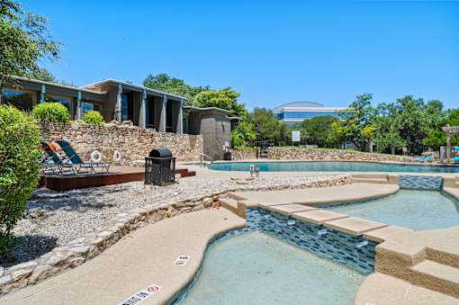 Multi level pool area with stone accents at Skyline at Barton Creek Apartments, Austin, TX 78758