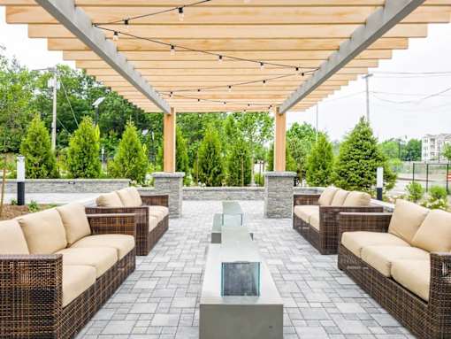 A patio with a table and chairs under a roof.