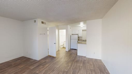 a living room and kitchen with a hard wood floor and white walls at La Terraza, Phoenix, 85018