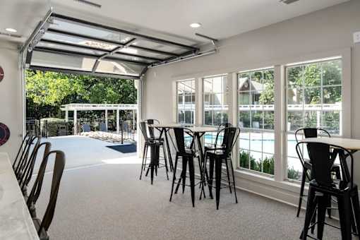 A room with a pool table and chairs.