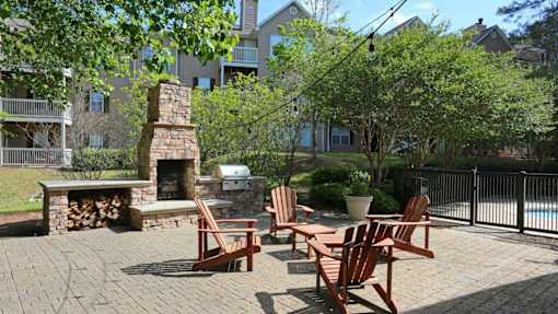 A backyard with a fireplace and chairs.