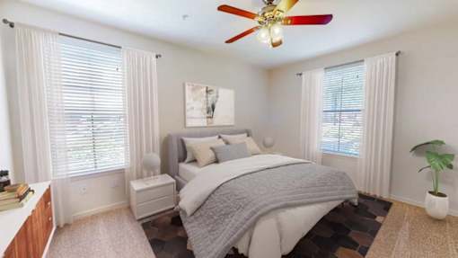 A bedroom with a large bed and a ceiling fan.