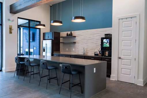A modern kitchen with a bar area and a television on the wall.
