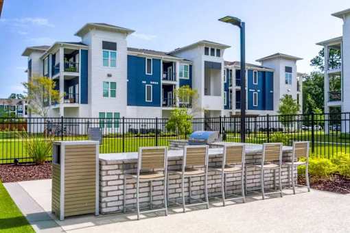 A row of chairs are lined up on a sidewalk in front of a building.