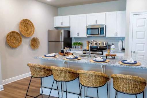 A kitchen with a refrigerator, microwave, oven, and sink.