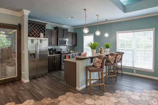 A kitchen with a refrigerator, oven, and sink.
