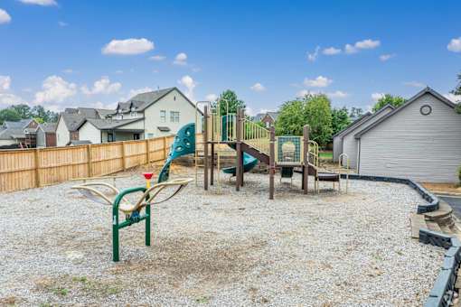 A playground with a green slide and a red and yellow slide.