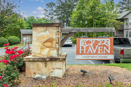 A stone pillar with a sign that says Haven Apartment Homes.