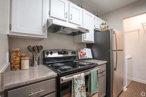 A kitchen with a black stove top oven and a black refrigerator.