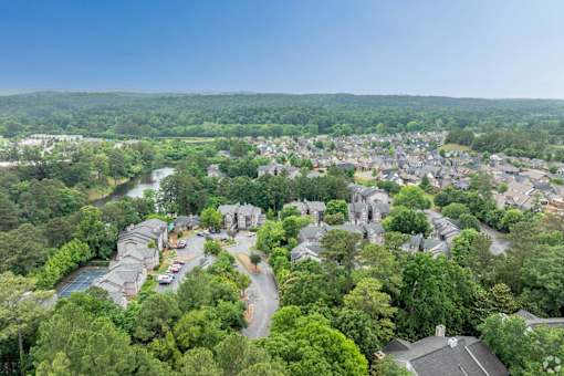 A bird's eye view of a residential area with houses surrounded by lush greenery.