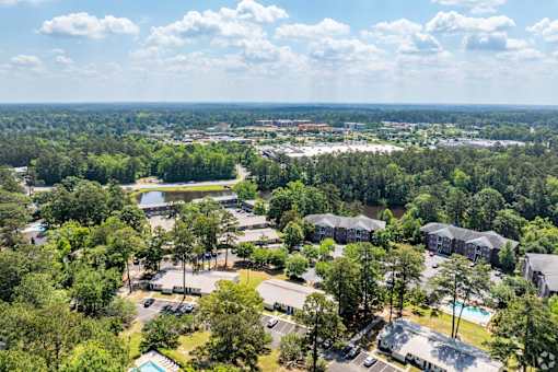 A bird's eye view of a resort with a swimming pool and surrounding greenery.