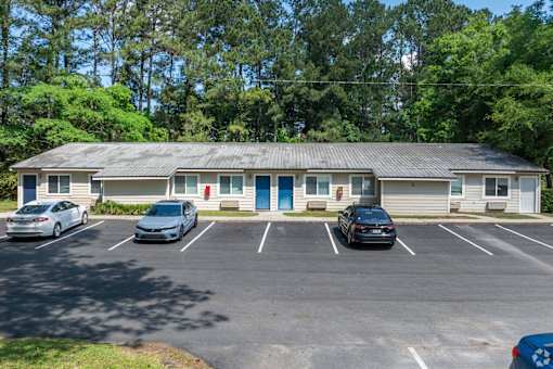 A parking lot with cars and a building in the background.