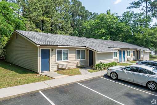 A small building with a car parked in front of it.