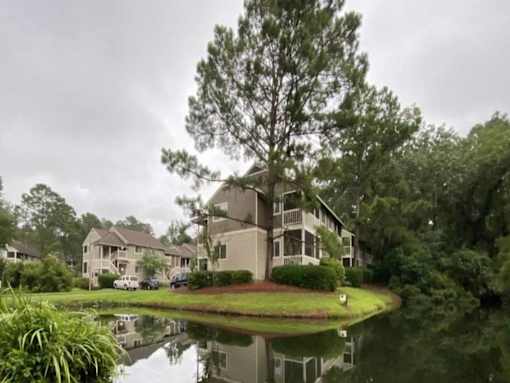 A house with a pond in front of it.