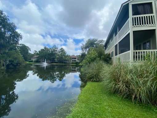 A serene scene of a lake with a building on the right side.