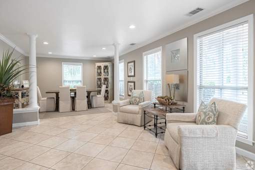 A spacious living room with a large window and a view of the trees outside.