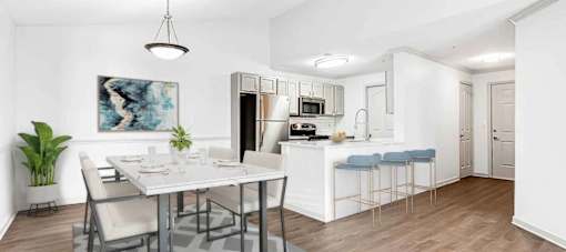 A modern kitchen with a dining table and chairs.