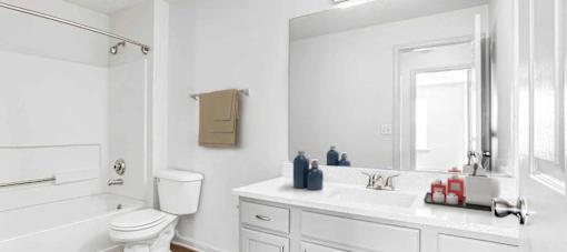 A white bathroom with a toilet, sink, and shower.