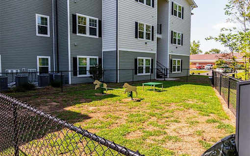 A view of a fenced backyard with a playset.