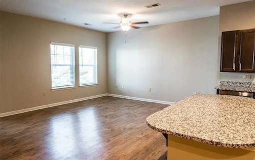A room with a ceiling fan and a table with a chair.