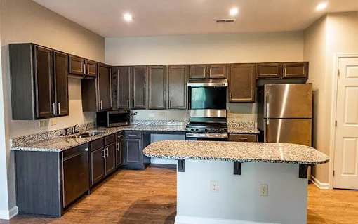 A kitchen with dark wood cabinets and stainless steel appliances.
