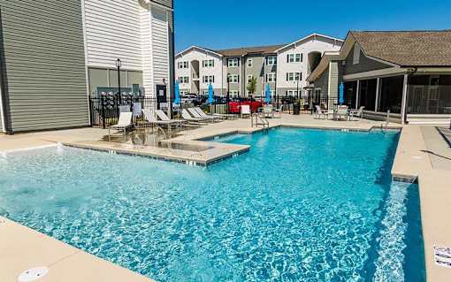 A swimming pool with a slide and sun loungers.