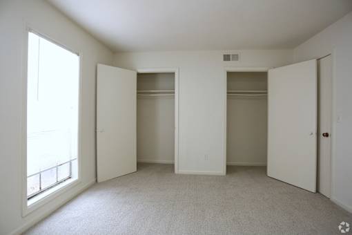 A white room with three doors and a window.