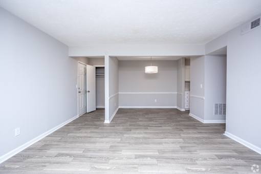 A spacious room with a light grey floor and white walls.