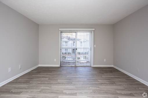 A room with a sliding door leading to a balcony.