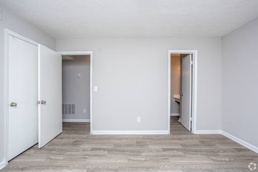 A room with a white door and a grey floor.