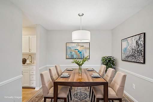 A dining room with a wooden table and chairs.