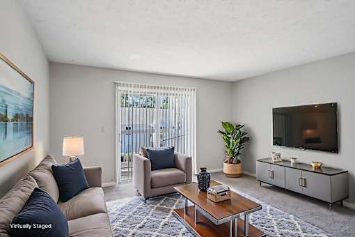 A living room with a couch, chair, and television.