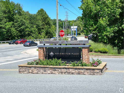 A stop sign is in front of a Kennington Place sign.