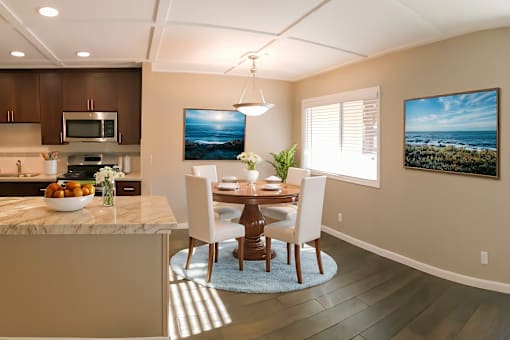 A modern kitchen with a dining table and chairs.