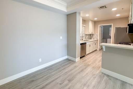 A kitchen with a white countertop and a grey floor.