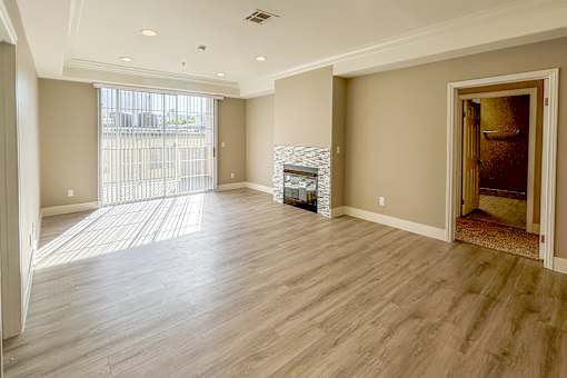 A spacious living room with a fireplace and hardwood floors.