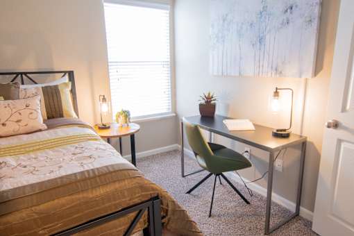 a bedroom with a bed and a desk with a chair