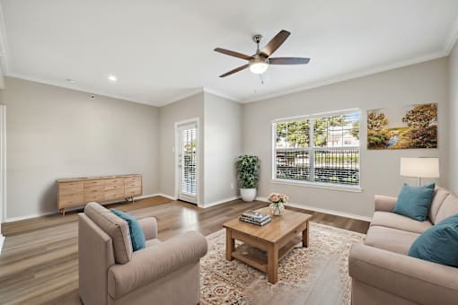 A living room with a beige sofa, a wooden coffee table, and a ceiling fan.